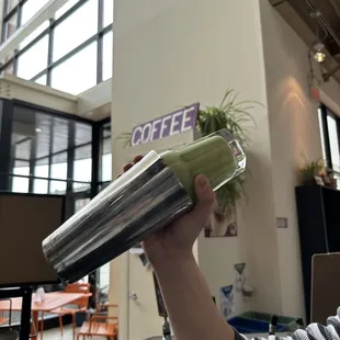 a person holding a cup of coffee