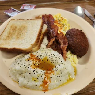 a breakfast plate with eggs, toast, bacon and toast