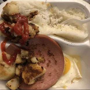 Homemade potatoes  with grits along with eggs  sunny side up and fried bologna