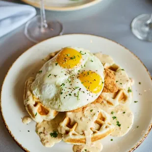 a plate of waffles with a fried egg on top