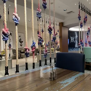 a dining area with ropes hanging from the ceiling