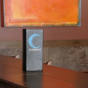 a table and chairs with a painting in the background