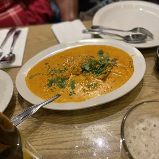 a plate of curry and a glass of beer