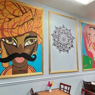 a wall of paintings in a restaurant