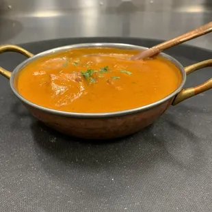 a bowl of curry with wooden spoons