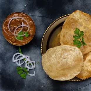 a bowl of roti bread and a bowl of onion chuya