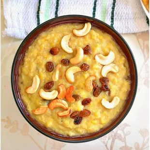 a bowl of rice pudding topped with cashews and raisins