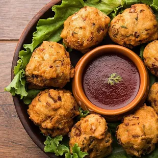 a plate of fried meatballs with a dipping sauce