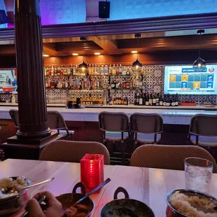 a view of a restaurant with a bar in the background