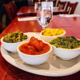 three bowls of curry on a plate