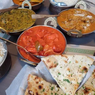 Butter chicken (top continue clockwise), korma goat, chicken tikka masala, spinach palak paneer, with garlic naan
