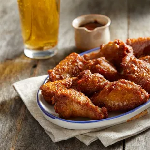 a plate of chicken wings and a glass of beer