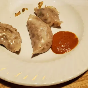 a plate of dumplings and a bowl of rice