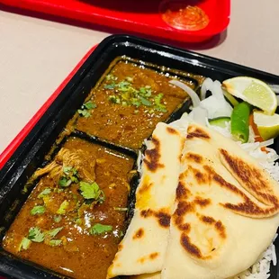 a plate of rice, naan bread, and a side of naan bread