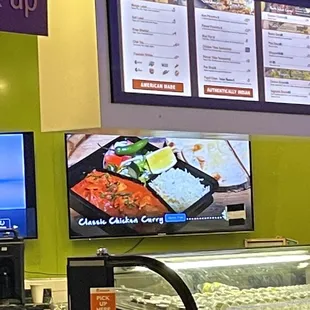 a restaurant counter with a menu on the wall