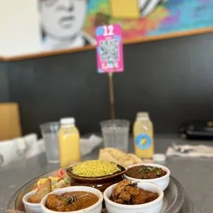three bowls of curry and a plate of rice