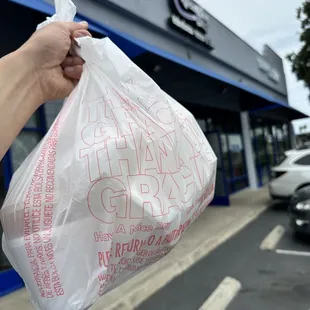 a person holding a bag of food