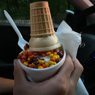 a person holding a bowl of dessert