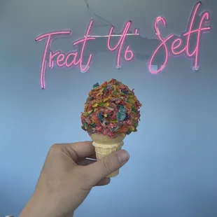 a hand holding an ice cream cone