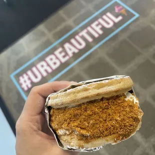 a hand holding a sandwich