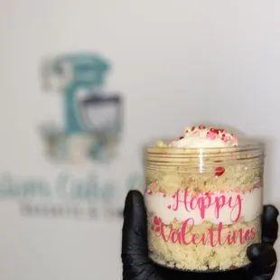 a hand holding a jar of cake