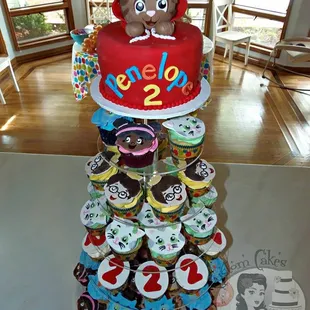 a three tiered cake with cupcakes