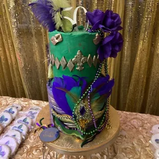 Custom Corporate Cookie Solution Fleur-de-lis cookies complimenting the Mardis Gras themed birthday cake on the dessert table.