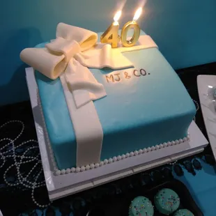 a blue cake with a bow and candles
