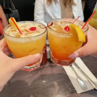 two people toasting drinks at a restaurant