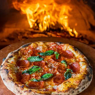 pepperoni and basil on a pizza