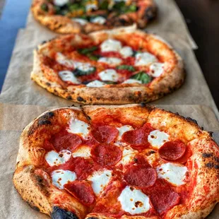 three pizzas on a table