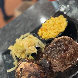 meat and vegetables on a black plate