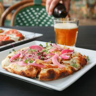 a plate of pizza and a glass of beer