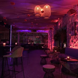 the interior of a restaurant with purple lighting