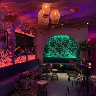 the interior of a restaurant with purple lighting