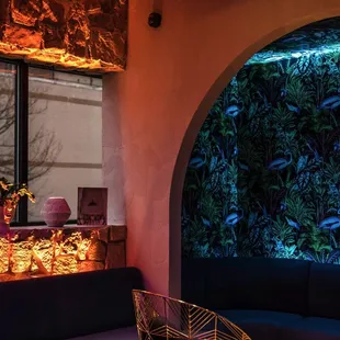 the interior of a restaurant with a wall of plants