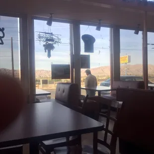 a man standing in the window of a restaurant