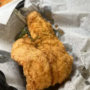 a piece of fried chicken in a basket