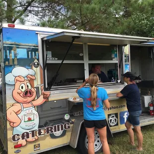 a couple of people ordering food from a food truck