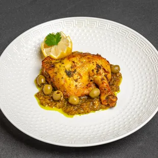 a plate of food with chicken and olives