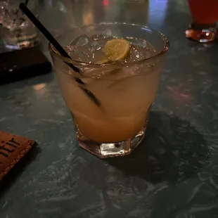 a cocktail with a lime slice