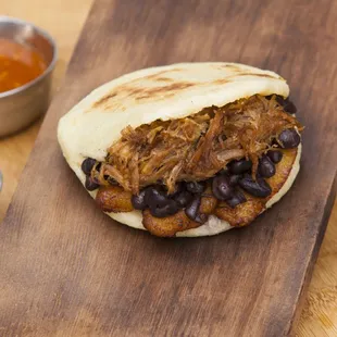 a pulled pork sandwich on a cutting board