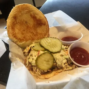a sandwich with pickles and a side of ketchup