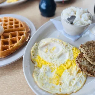 Hearty Breakfast with fully cooked easy over eggs, grits, chicken sausage, and a Belgian waffle