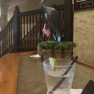 a glass of water and a statue of a heron