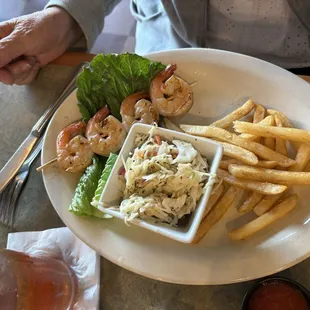 Petite order of grilled shrimp with coleslaw and fries.
