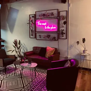 a living room with a neon sign