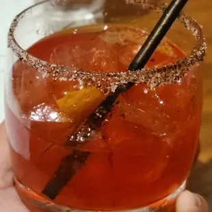 a hand holding a glass of cocktail