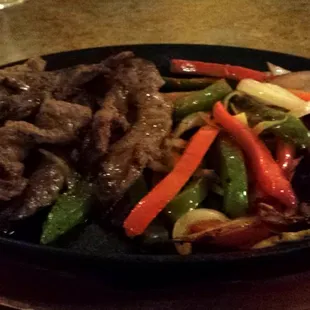 Steak fajitas with bell peppers and onions.