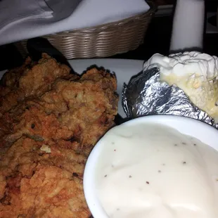 Chicken Fried Steak with Gravy &apos;on the side&apos; with a Baked Potatoes.